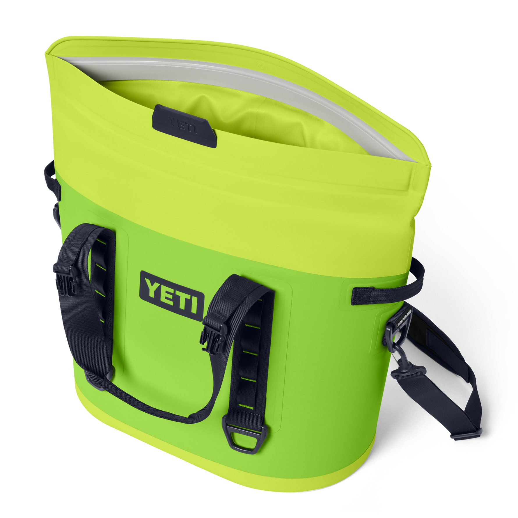 YETI Hopper M20 cooler bag in vibrant fluorescent green with its open top revealing the waterproof MagShield Access and equipped with black grab handles and a shoulder strap against a black studio background