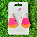 Acrylic earrings by Sandy Rizzo a pair of unique candy corn shaped earrings with sparkly white, neon pink, and glittery orange layers on a white display card set against bright green artificial grass