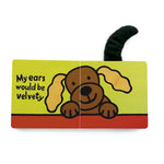 Children's book illustration of a smiling brown cartoon dog with fuzzy yellow ears and a fluffy black tail popping out, text reads My ears would be velvety on a bright lime green and red background