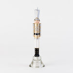 Nutcracker shaped taper candle in gold and silver uniform on a glass stand