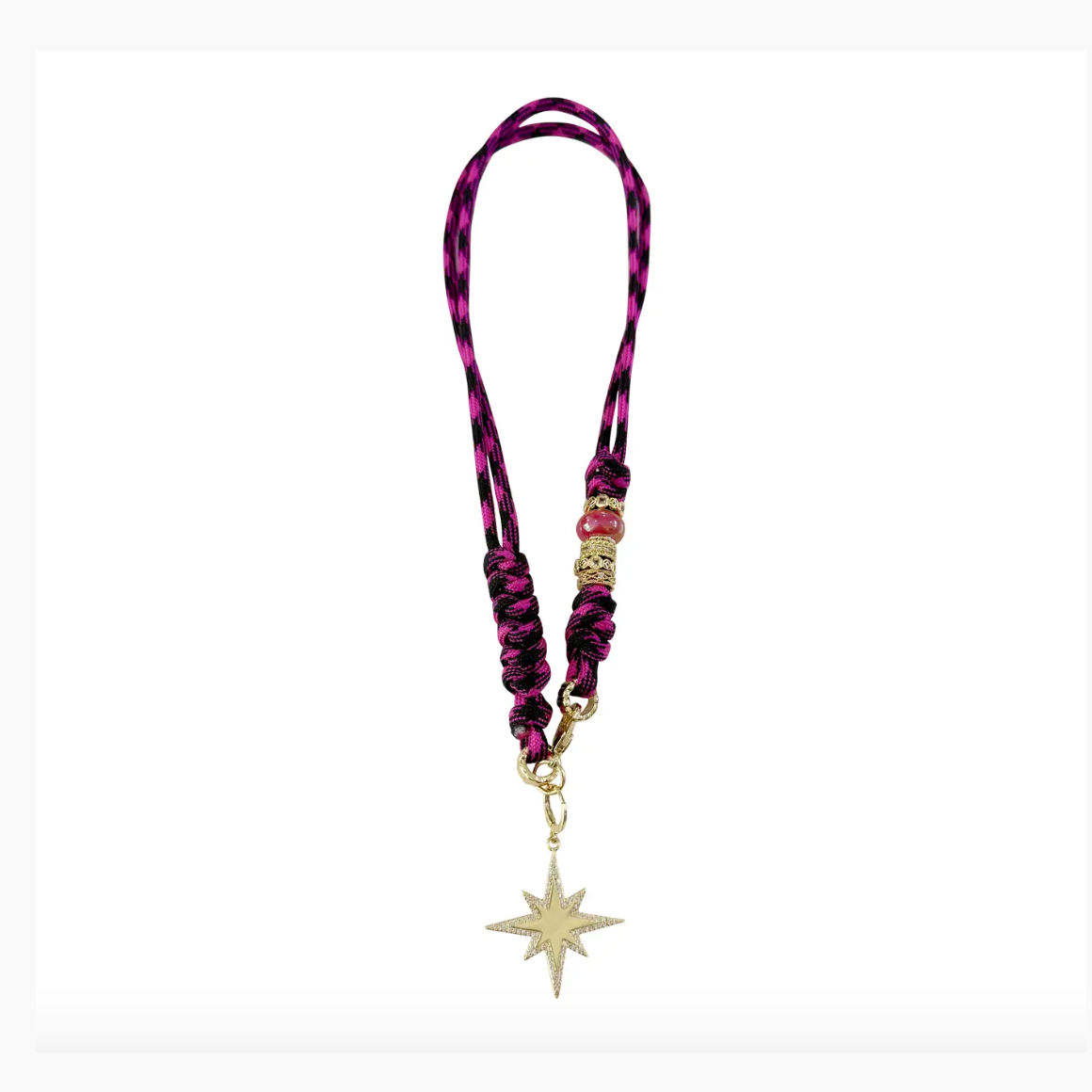 A designer lanyard with a braided pink and black patterned cord, featuring gold and pink beaded embellishments, and a sparkling gold starburst pendant adorned with pave diamonds
