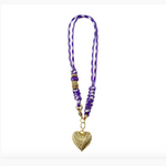 Jewelry a necklace with a purple and white braided cord, a textured gold corrugated heart pendant, and decorative gold and purple glass beads