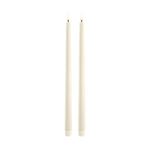 Two off white LED taper candles standing upright