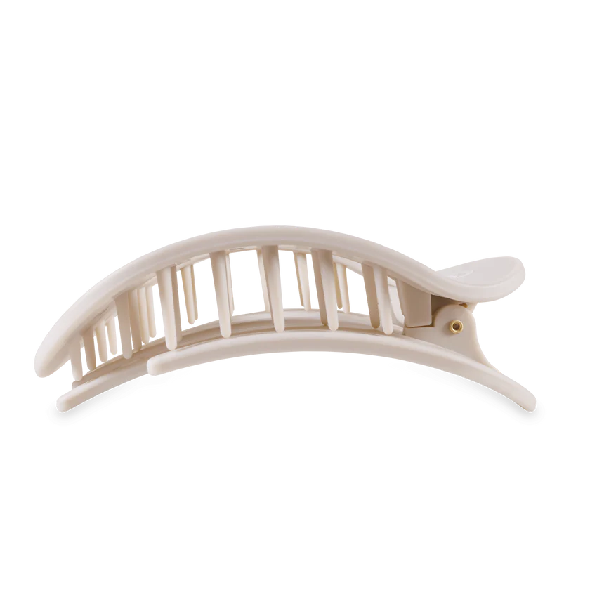 A large beige plastic hair claw clip featuring a curved minimalist design and a visible gold-toned hinge pin
