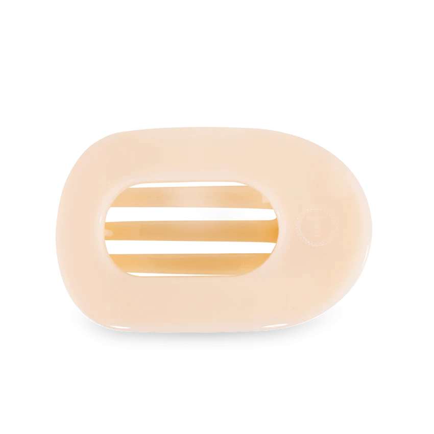 Pale peach oval razor cartridge with three visible blades and a faint circular logo against a solid black background