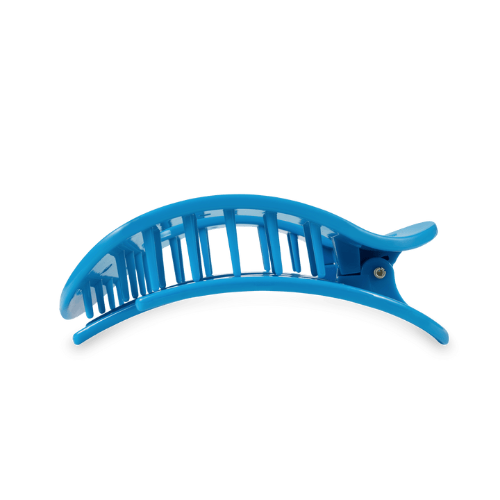 A bright blue plastic banana hair clip featuring a curved slotted top and a black rubberized bottom grip