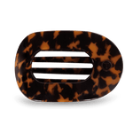 Oval tortoiseshell hair accessory featuring three horizontal slits and a subtle T logo on the right side
