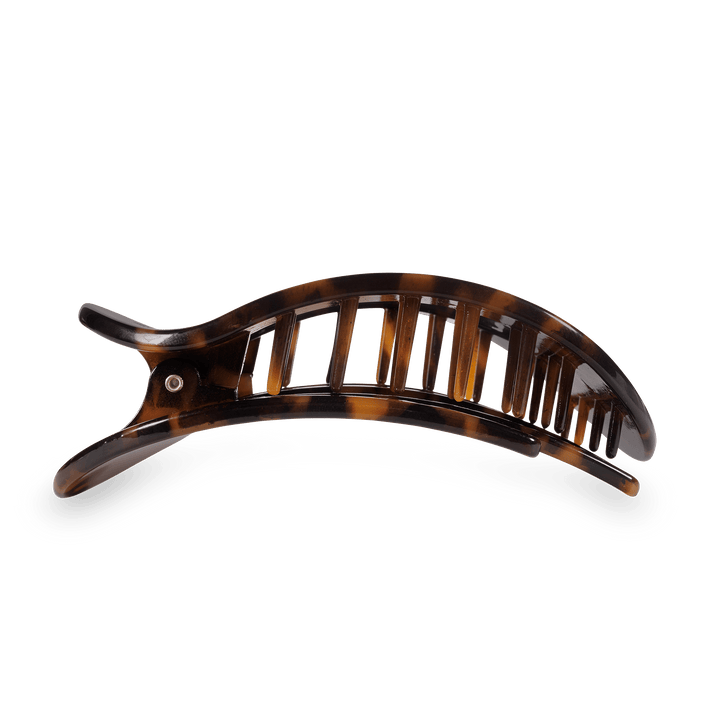 Tortoiseshell banana hair clip with brown and black mottled patterns, a curved design, and gapped teeth