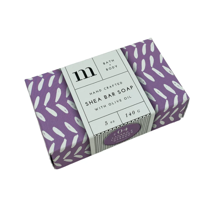 Rectangular bar of shea soap in purple patterned paper packaging with a white label