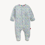 White footed baby sleepsuit featuring a delicate pastel floral print in light blue, purple, and yellow, accented with a vibrant rainbow-striped collar and visible eco-friendly label