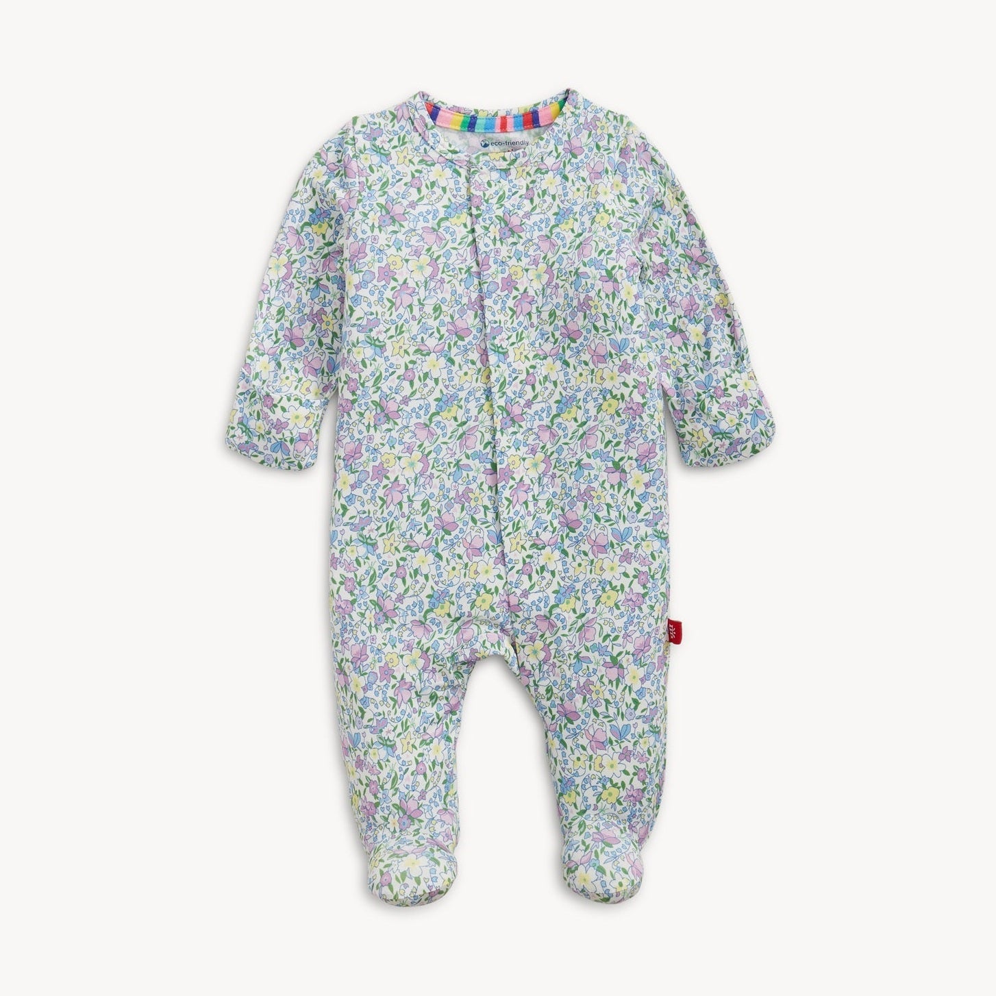 White footed baby sleepsuit featuring a delicate pastel floral print in light blue, purple, and yellow, accented with a vibrant rainbow-striped collar and visible eco-friendly label