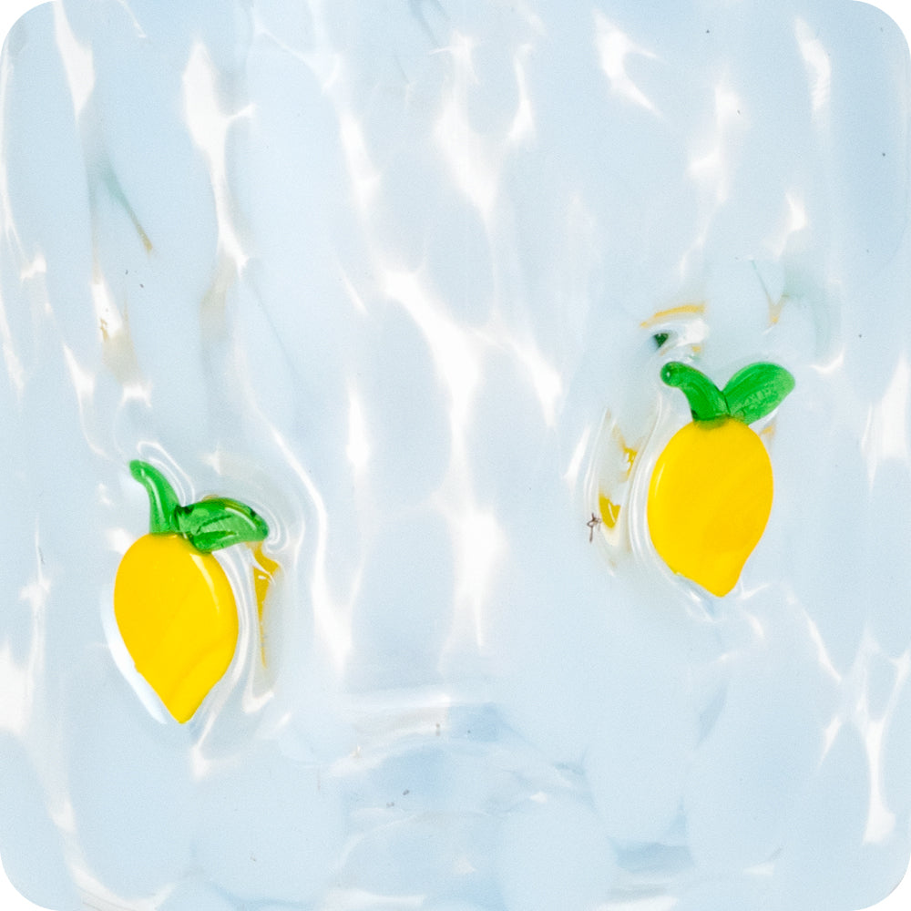 Two yellow lemon glass charms embedded in textured light blue glass