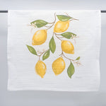 Printed fabric art by HOME MALONE featuring an illustration of lemon branches on a white kitchen towel with six bright yellow lemons fresh green leaves and small white blossoms