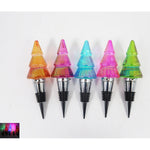 Five colorful glass Christmas tree wine stoppers in a row