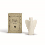 Small white ceramic angel figurine next to a cardboard box labeled Little guardian angel