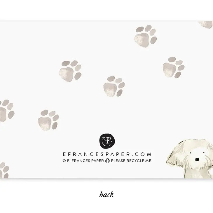 E. Frances Paper watercolor illustration on a card back featuring a cute white fluffy dog with black eyes and nose peeking from the bottom right, surrounded by scattered faded grey-beige paw prints, and company branding