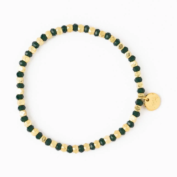 A gold and dark green beaded bracelet featuring alternating faceted beads and a small round gold charm with an etched design