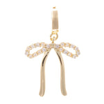 Gold-tone jewelry charm in a delicate bow shape adorned with sparkling pavé-set clear crystals and polished dangling ribbons suspended from a small circular hoop
