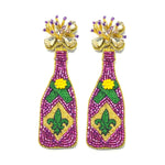 Handcrafted beaded Mardi Gras earrings shaped like purple champagne bottles featuring a green Fleur-de-lis, yellow flower accents, and gold and clear crystal tops