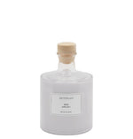 Archipelago Milk bubble bath in a clear glass bottle with a wooden stopper