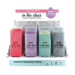 Lemon Lavender "in the clear" makeup removing towels displayed in retail packaging, featuring four towels in coral pink, lavender purple, mint green, and grey, each with a sleepy eye graphic and a top banner stating "clear the day away with just warm water"