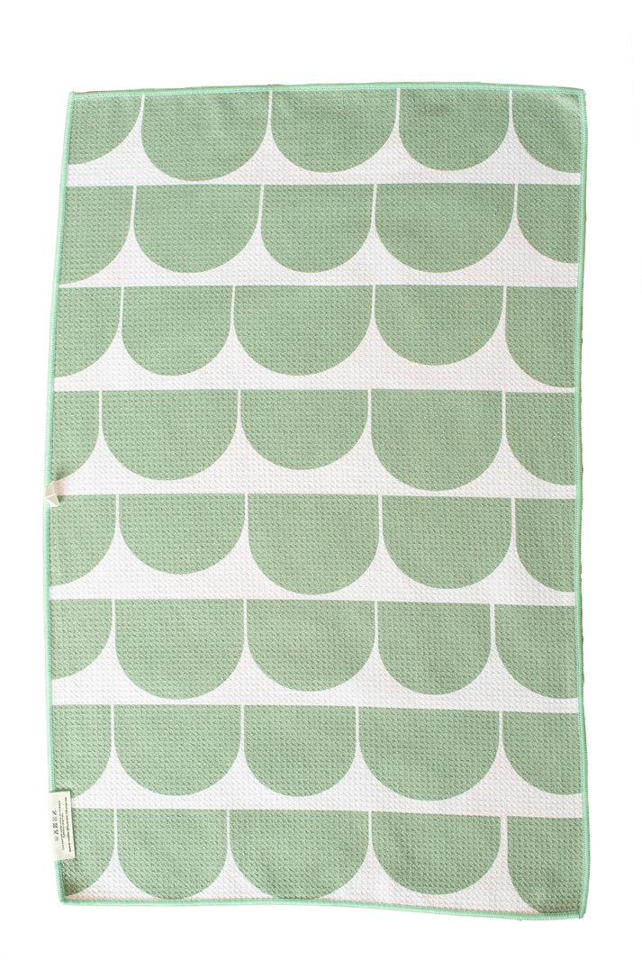 Waffle weave textile featuring a repeating sage green semi-circular pattern on a white background with a thin green border