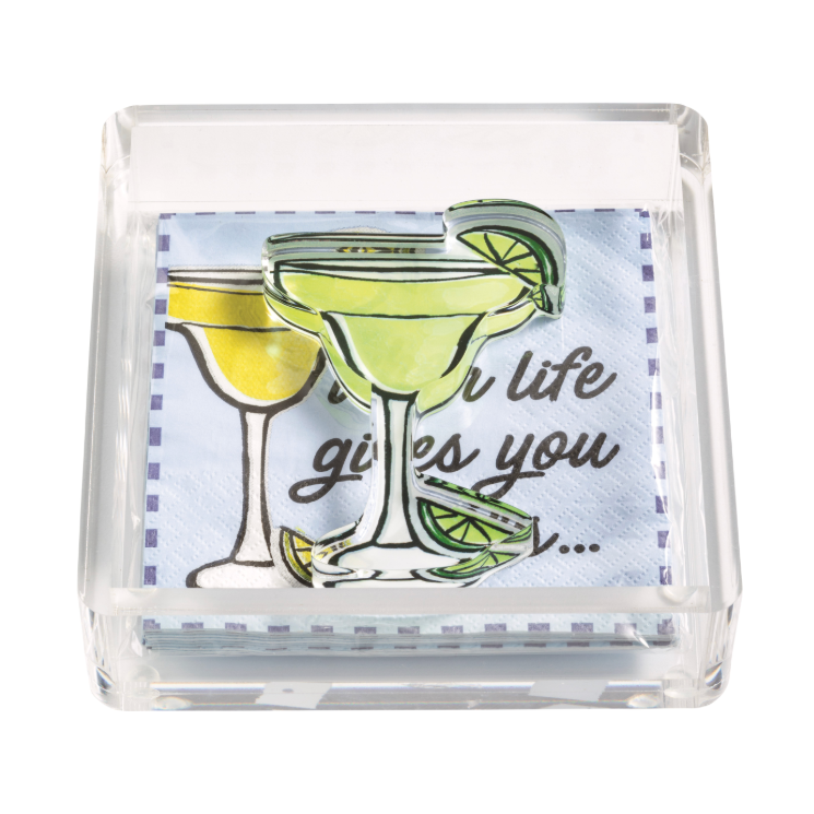 Clear acrylic napkin holder with light blue cocktail-themed napkins featuring a partial When life gives you quote and a bright green margarita glass decorative weight with a lime slice