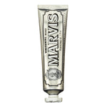 Studio product photography by Marvis of a Whitening Mint toothpaste tube centered on a white background featuring its signature silver metallic finish, bold vintage-style black typography, and an intricate decorative portrait crest