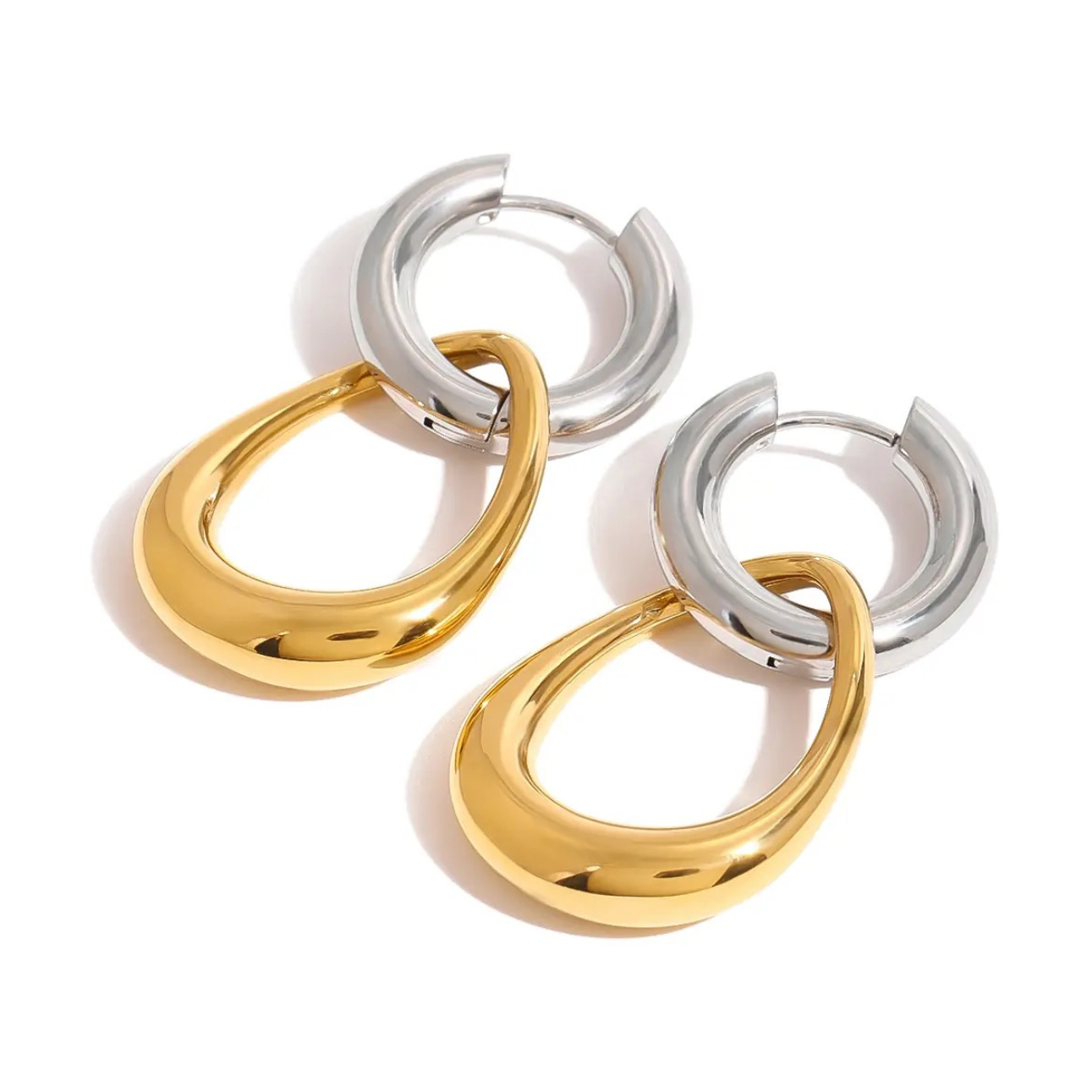 A pair of modern two-tone drop earrings featuring chunky silver hoops linked to shiny gold teardrop pendants on a white background