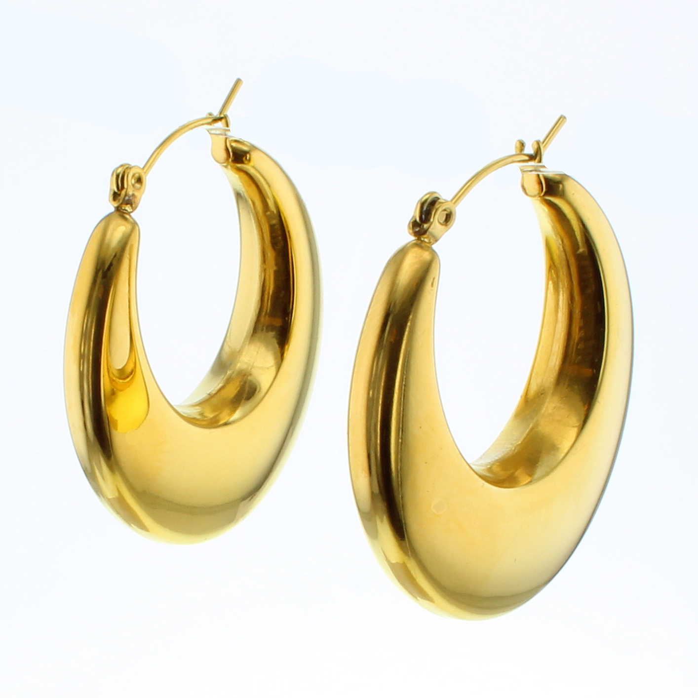 A pair of gleaming yellow gold chunky oval hoop earrings featuring a highly reflective polished surface