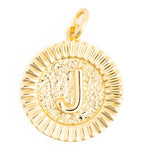 Polished gold pendant featuring a prominent smooth capital J centered on a hammered textured disk with a radiating ridged border