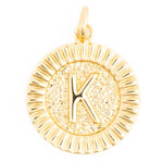 Gold metal round pendant featuring an embossed capital letter K on a textured interior with a fluted outer edge