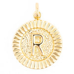 Gold jewelry pendant depicting a shiny circular charm with an embossed capital letter R set against a textured base and a fluted outer edge