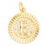 Gold circular pendant with a prominent raised capital E on a textured hammered background, framed by a ridged radiating border and a small bail loop