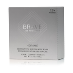 Grey product box for Brave by Spongellé Homme Buffer with built-in body wash, featuring a metallic silver logo, "12+ Washes", and "Scrub Cleanse Hydrate" text, on a reflective white surface