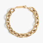 Gold chunky chain bracelet with polished oval links and a lobster claw clasp featuring an engraved rectangular tag on a white background
