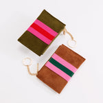 Two suede coin purses with striped fabric accents and gold keychains