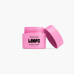 A vibrant pink Loops Double Take Glow Lip Mask jar with bold black text and its lid tilted open on a white studio background