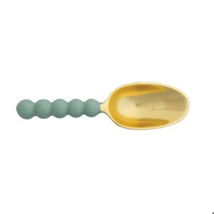 Product image of a modern golden scoop spoon with a sage green beaded ergonomic handle
