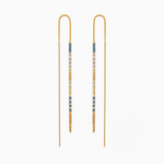Gold threader earrings featuring delicate chains, slender gold bars, and square beads in soft blue, pale pink, and natural beige tones