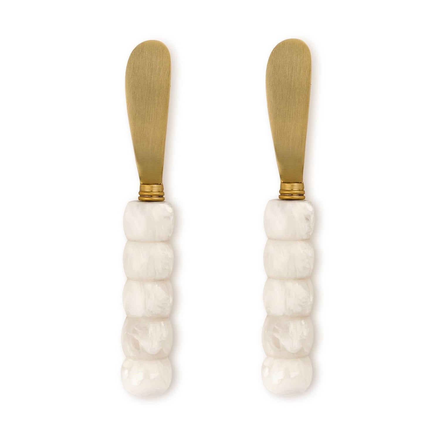 Gold-plated stainless steel and resin spreader knives featuring white marbled beaded handles and matte gold-tone blades set against a plain white background