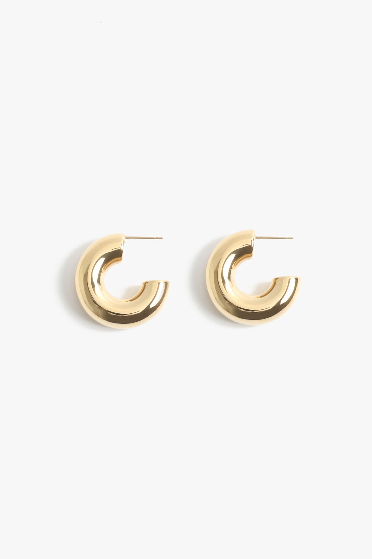 A pair of chunky polished yellow gold C-hoop earrings with post backs on a clean white background