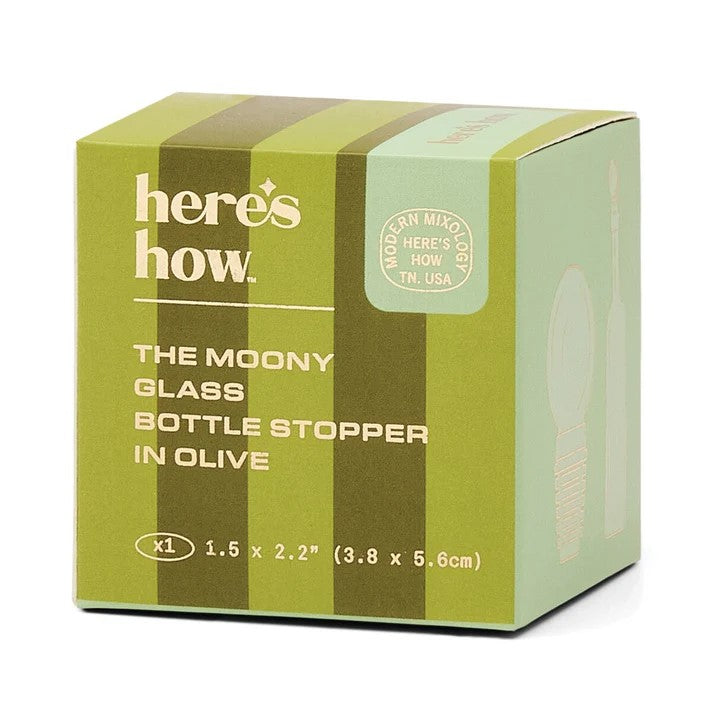 Product packaging by Here's How for The Moony Glass Bottle Stopper in Olive, featuring a two-toned olive green box with vertical stripes, a circular Modern Mixology TN USA seal, and 1.5 by 2.2 inch dimensions