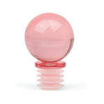 Translucent pink spherical glass bottle stopper with a ribbed silicone base