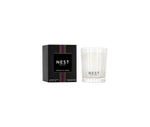 NEST NEW YORK Moroccan Amber scented candle and black box featuring purple and gold striped bands on the packaging and a clear ribbed glass holder with white wax