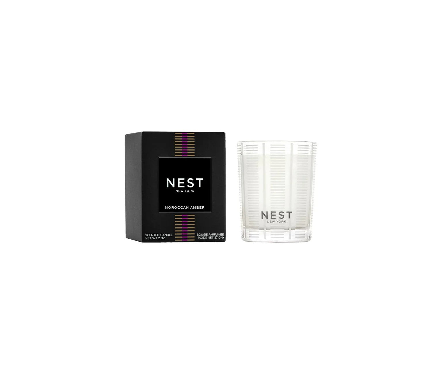 NEST NEW YORK Moroccan Amber scented candle and black box featuring purple and gold striped bands on the packaging and a clear ribbed glass holder with white wax