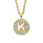 Gold pavé disc necklace with a cutout initial K