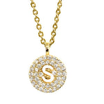 Gold pavé disc necklace with a cutout initial S
