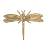 Golden metal decorative object of an ornate dragonfly with detailed ribbed wings and a segmented body