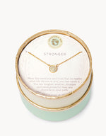 Spartina 449 Daufuskie Island 18KT gold plated necklace featuring a circular pave crystal pendant displayed in a mint green and cream round box with the word STRONGER and an inspirational message on the card